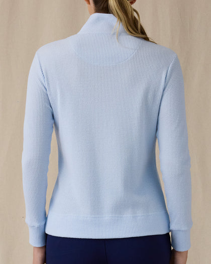 Women's Hills Quarter Zip in Lake, back view on model featuring a light blue waffle-knit quarter-zip pullover with mock neck collar and ribbed cuffs, paired with navy pants