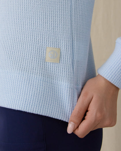 Women's Hills Quarter Zip in Lake, detail close-up view featuring the waffle-knit texture and Straight Down logo patch at the lower hem