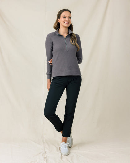 Woman wearing the Hills Quarter Zip in Nightshade with black pants and white golf shoes.