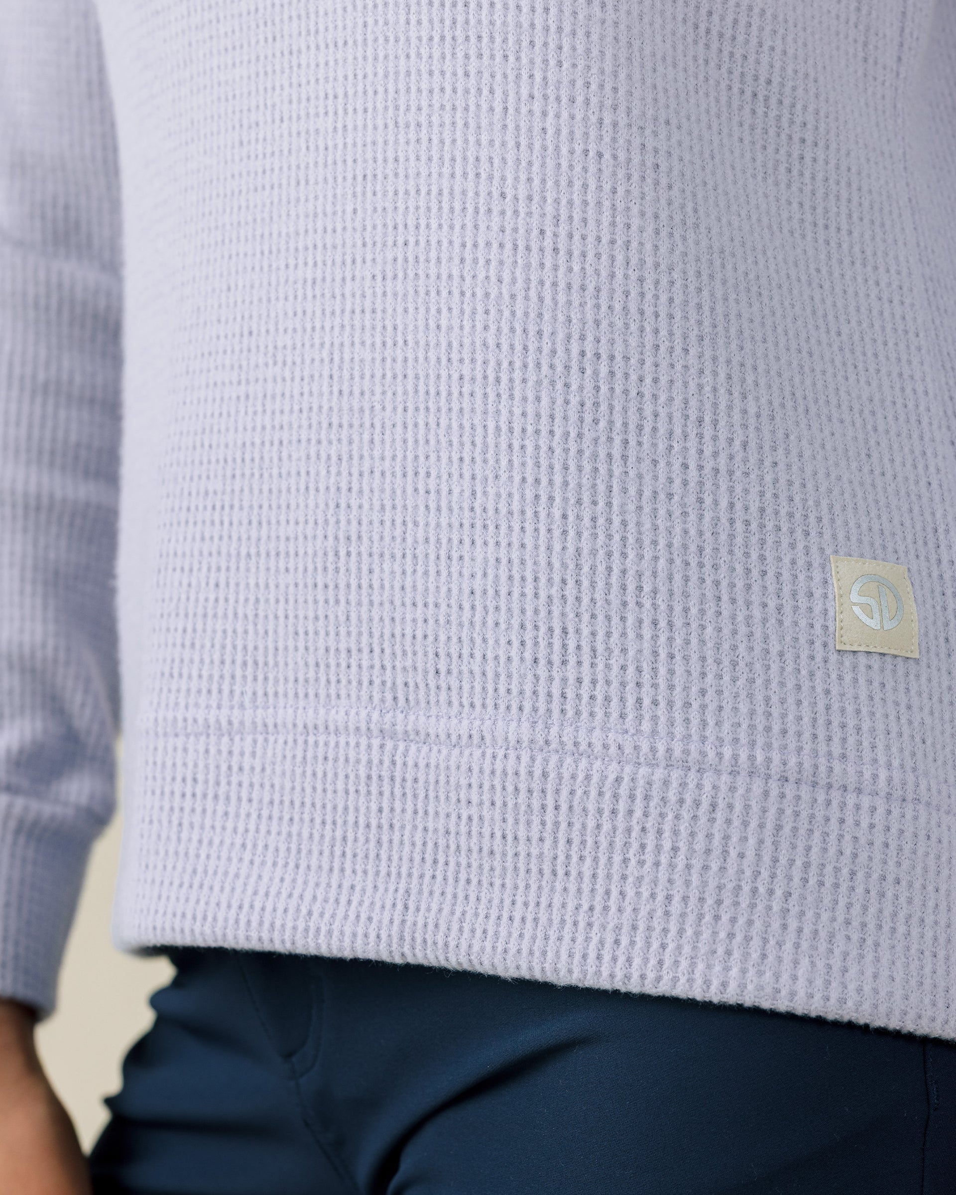 Close-up of the Straight Down Hills Quarter Zip in Cosmic Blue highlighting the soft waffle knit fabric and signature logo hem patch