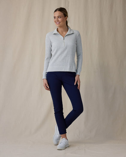Women's Hills Quarter Zip in New Heather, front full-length view featuring a light heather gray waffle-knit quarter zip pullover with spread collar and silver zipper paired with navy pants and white shoes