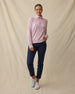 Woman wearing the Collette Quarter Zip in Pink Dawn fully zipped with navy golf pants