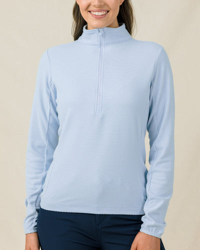 Woman wearing the Lorna Half Zip in Lake, showing the textured fabric, high collar, and streamlined fit.