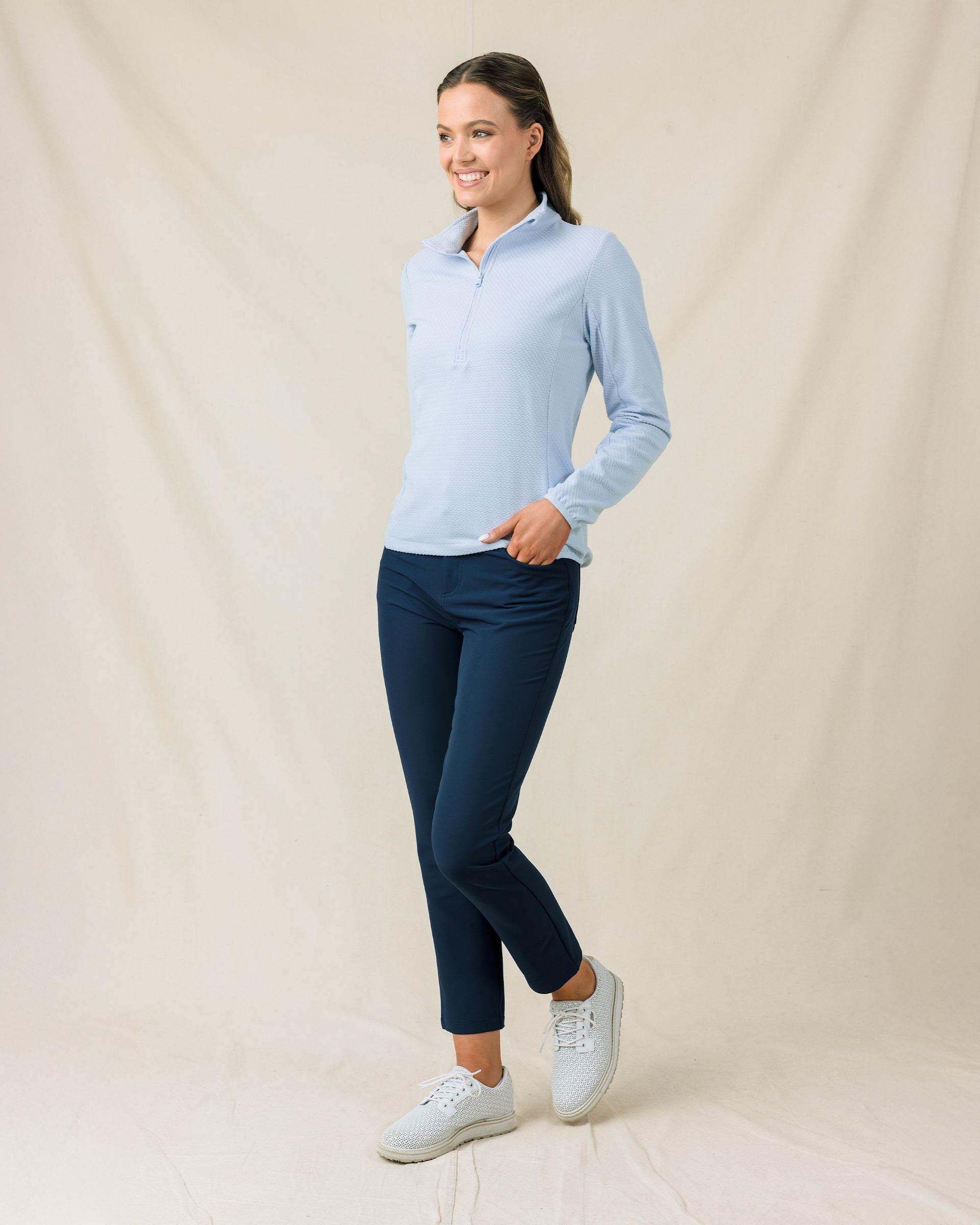 Woman wearing the Lorna Half Zip in Lake, styled with navy pants and white golf shoes.