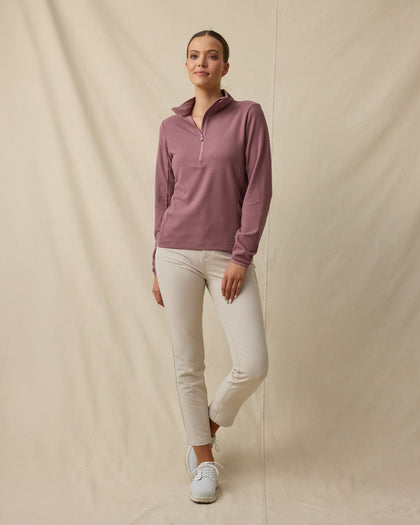 Model wearing the Lorna Half Zip in Oxblood Red with cream golf pants, collar unzipped