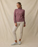 Model wearing the Lorna Half Zip in Oxblood Red with cream golf pants, collar zipped