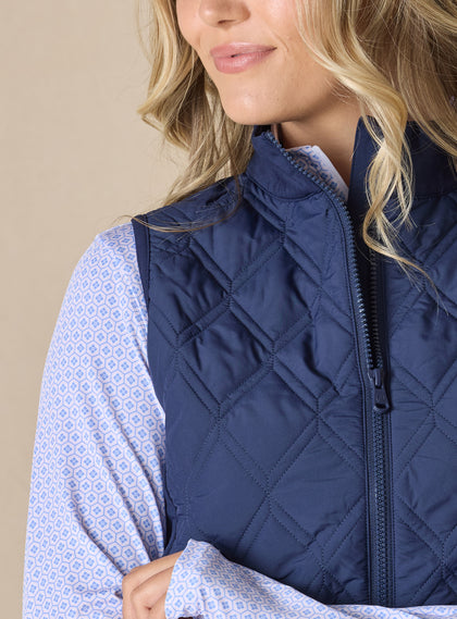 Women's 126th U.S. Open Hestia Vest in New Indigo, close-up model view featuring the diamond quilted texture and full zip closure detail