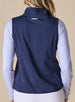 Women's Hestia Vest in New Indigo, back view on model featuring a solid navy stretch back panel with white embroidered Straight Down wings logo