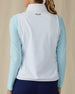 Women's Hestia Vest in White, back view on model featuring a white quilted vest with smooth back panel and Straight Down logo at upper back, layered over a mint long-sleeve top, paired with navy pants