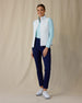 Women's Hestia Vest in White, full length front view on model featuring a white quilted diamond-pattern full-zip vest worn open over a mint long-sleeve top, paired with navy pants and white golf shoes