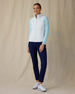Women's Hestia Vest in White, full length front view on model featuring a white quilted diamond-pattern full-zip vest layered over a mint long-sleeve top, paired with navy pants and white golf shoes