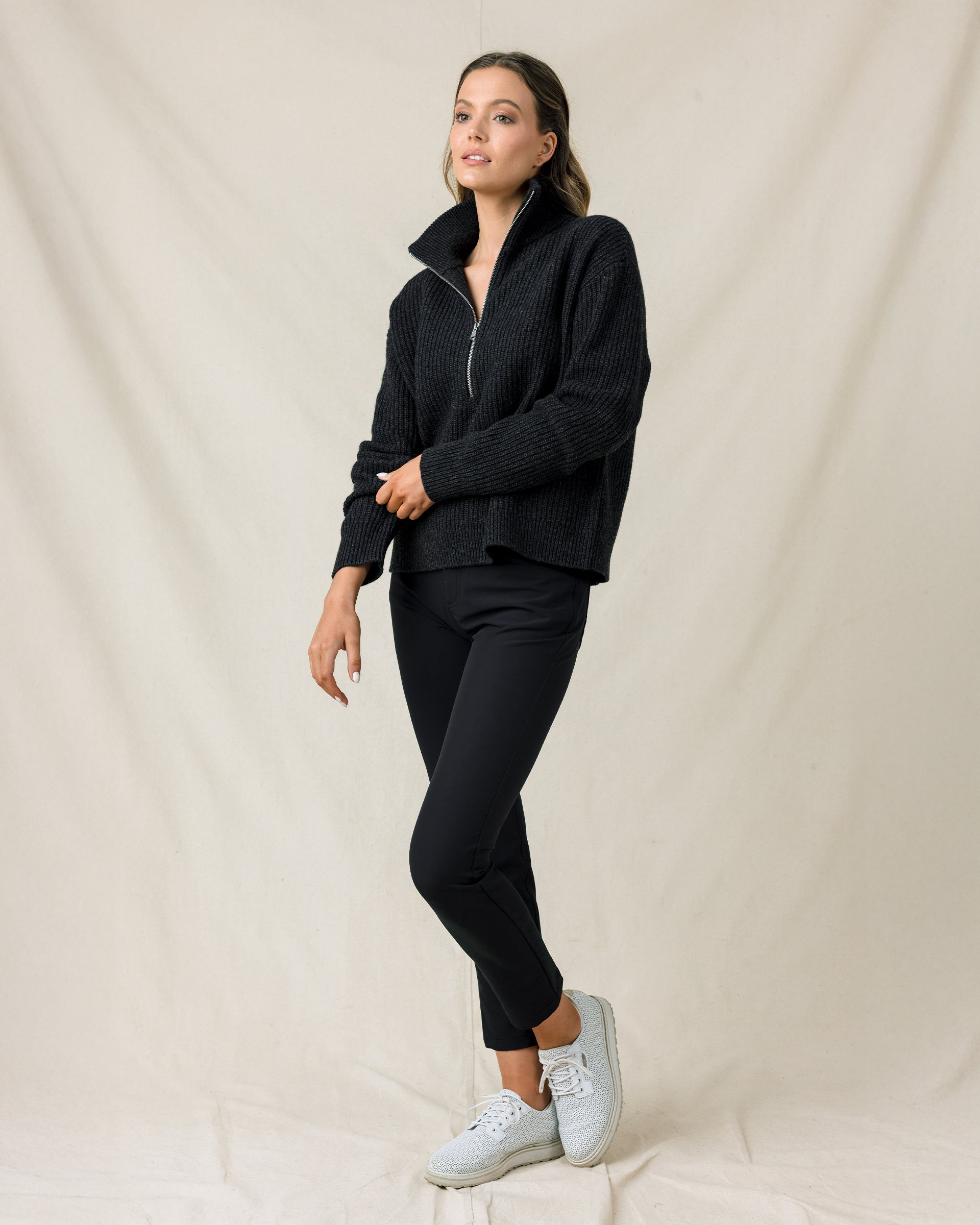 Woman wearing the Devon Half Zip Sweater in Charcoal with black pants and white golf shoes.