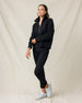 Woman wearing the Devon Half Zip Sweater in Charcoal with black pants and white golf shoes.