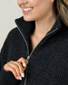 Close-up of the Devon Half Zip Sweater in Charcoal showing the ribbed knit texture, silver zipper, and structured high collar.