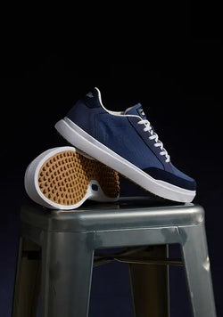 Cruise Sneaker in Moonlight stacked on a stool with a black backdrop. 