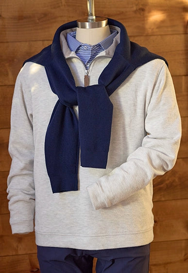 Men’s layered golf look with Montecito Quarter Zip pullover in light grey, collared shirt, and navy sweater draped over shoulders.